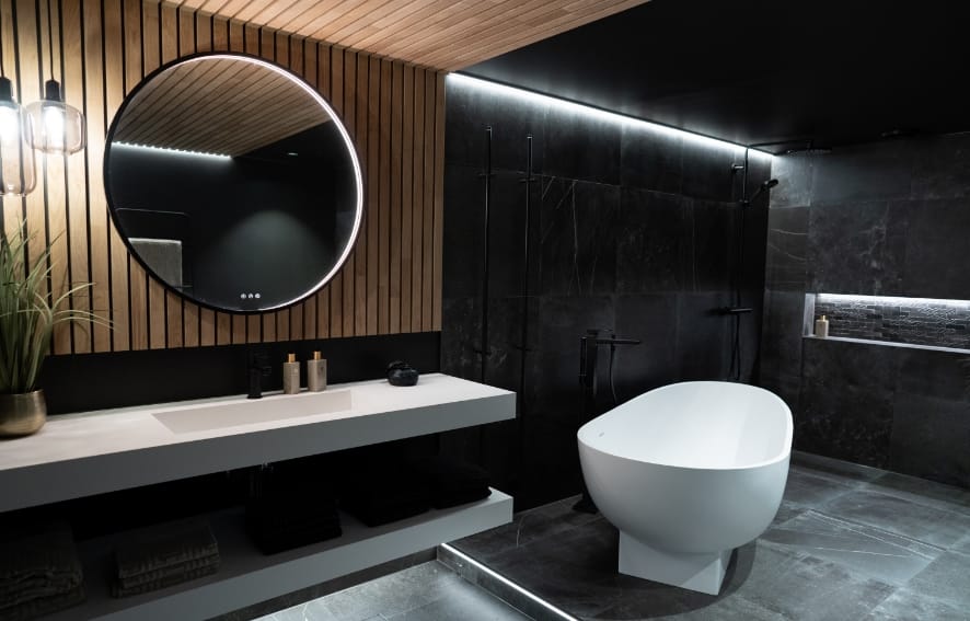 Eksklusivt bad med mørke flater, frittstående toalett og moderne uttrykk